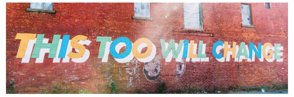 'This too will change' mural on brick wall.